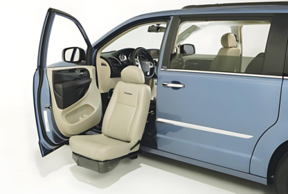 A blue minivan with one of its doors open displays a front passenger seat that can pivot and extend outside the vehicle.