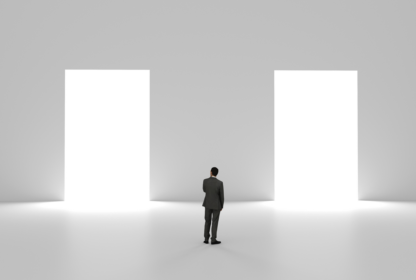 A man in a suit stands in a white room facing two large, illuminated doorways, contemplating which one to choose.