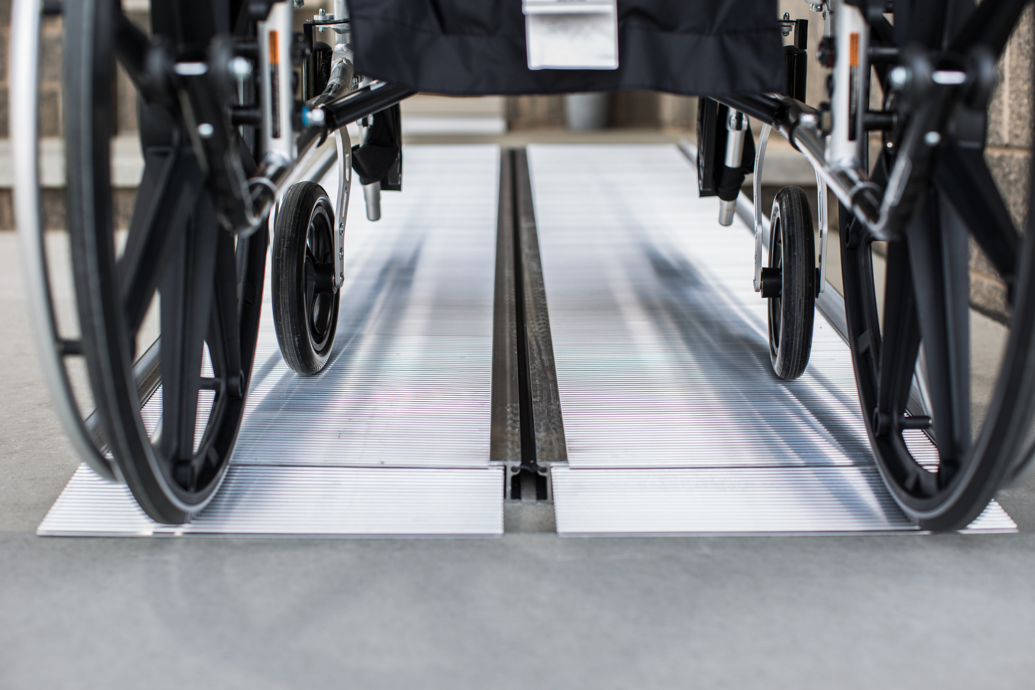 A wheelchair positioned on a metal ramp, ready to be used for accessibility purposes.