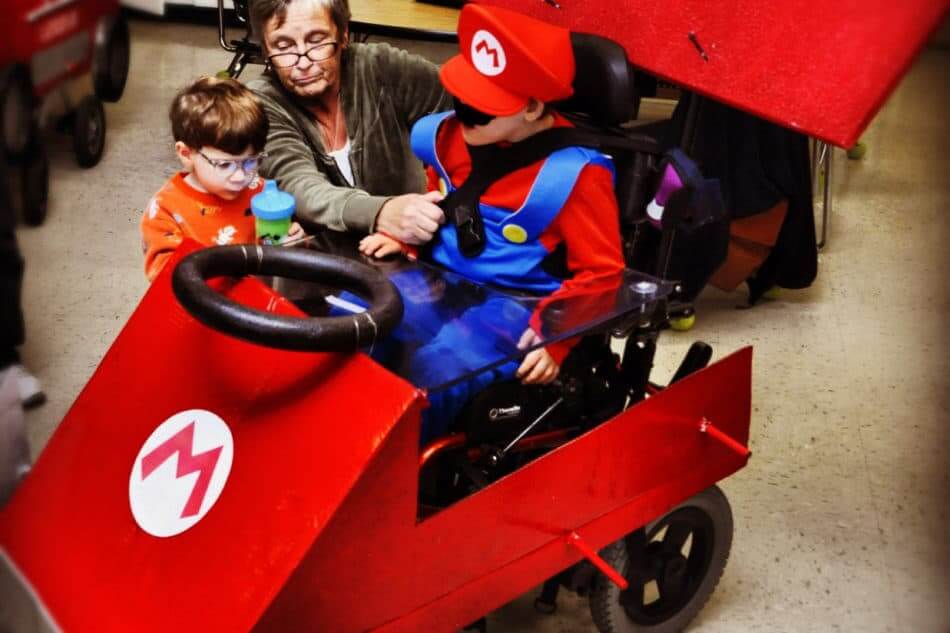 mario kart wheelchair with two kid and dad