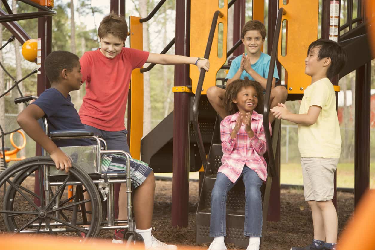 disabled child having fun with friends on the playground