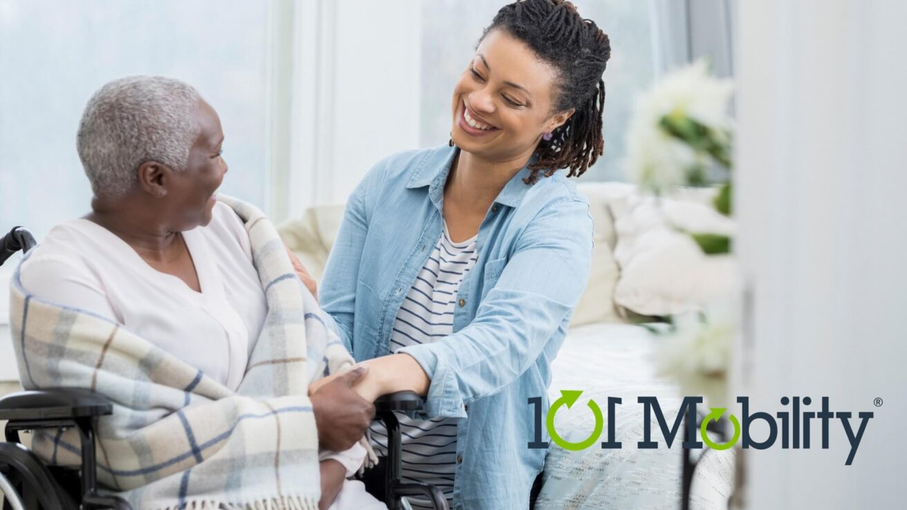 A caregiver helps an elderly person in a wheelchair. Both are smiling at each other. A logo for "101 Mobility" is visible in the bottom right corner.