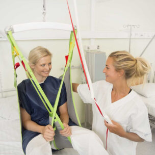 A woman using a patient lift at a hospital.