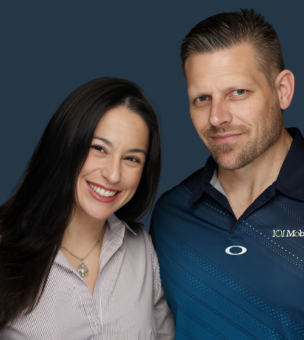 A woman in a striped shirt and a man in a dark blue polo with a "101 Mobility" logo stand together, both smiling against a plain dark background.