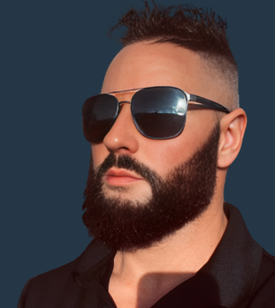 A person with a beard, wearing aviator sunglasses, and a black collared shirt poses against a dark background.