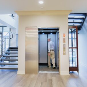 man walking into elevator in building.