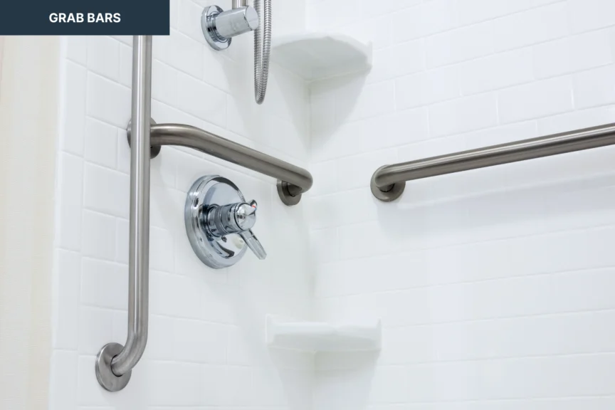 Shower with white tile walls, metal grab bars, and adjustable showerhead.